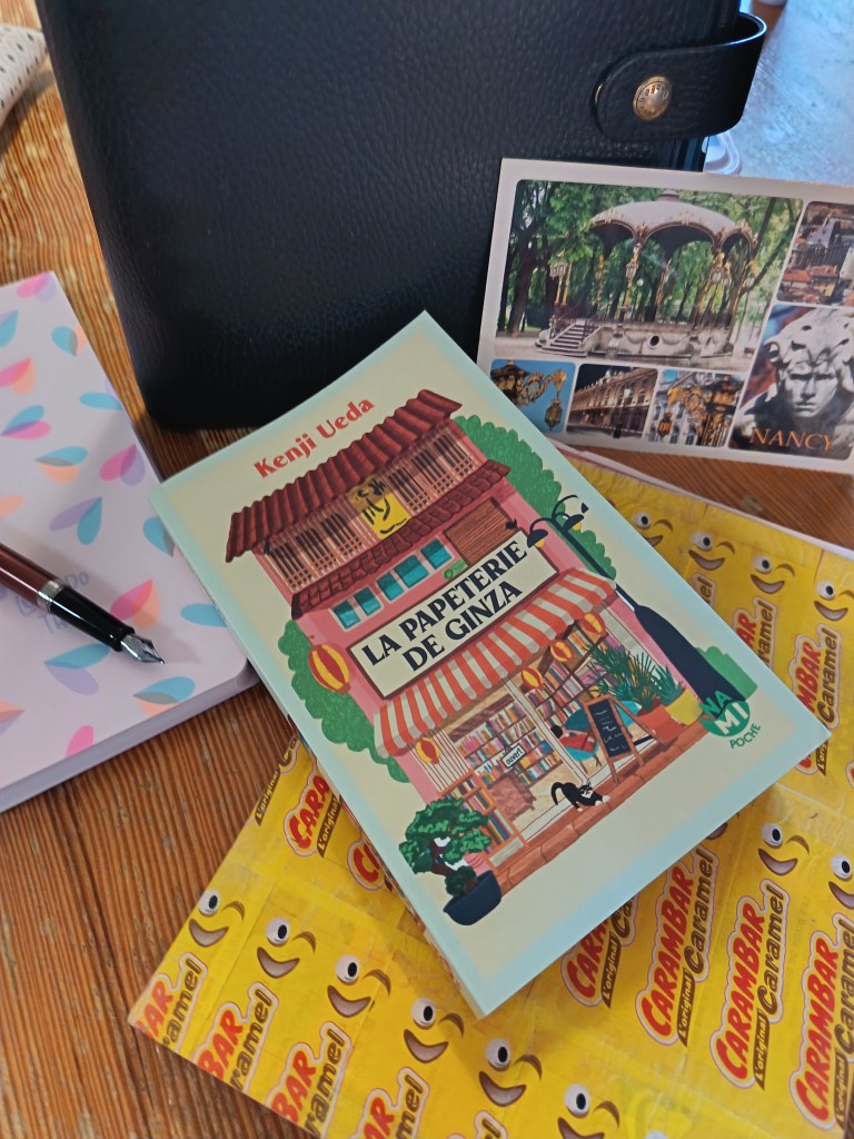 Photographie du roman La Papeterie de Ginza de Kenji Ueda, entouré d'un stylo-plume, d'un carnet et d'une carte postale.